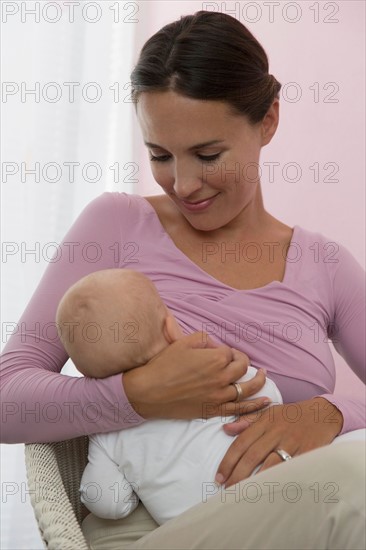 Mother breastfeeding baby daughter (6-11 months)