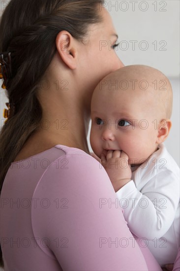 Mother holding baby daughter (6-11 months)