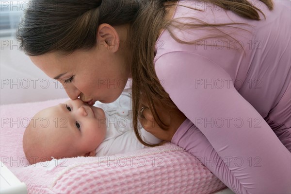 Mother kissing baby daughter (6-11 months)