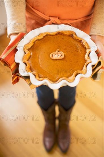 Woman holding pumpkin pie.