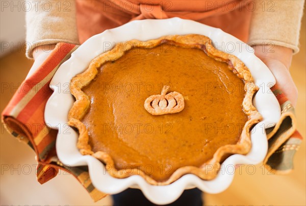 Woman holding pumpkin pie.