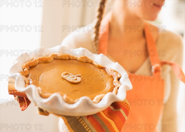 Woman holding pumpkin pie.