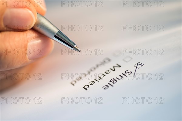 Close-up of hand filling out form.