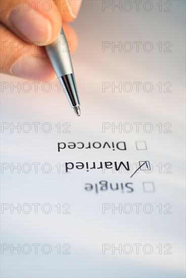 Close-up of hand filling out form.