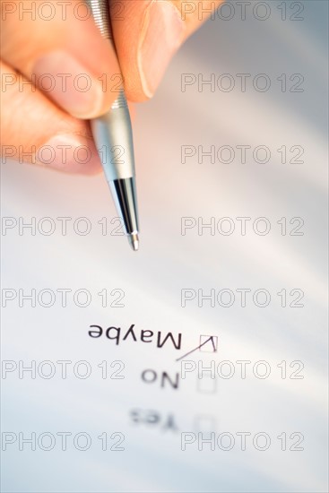 Close-up of hand filling out form.