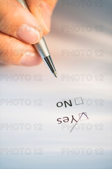 Close-up of hand filling out form.