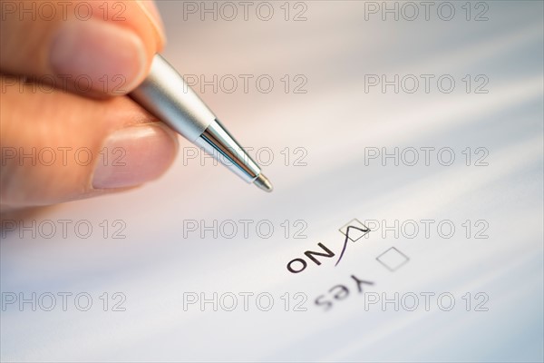 Close-up of hand filling out form.