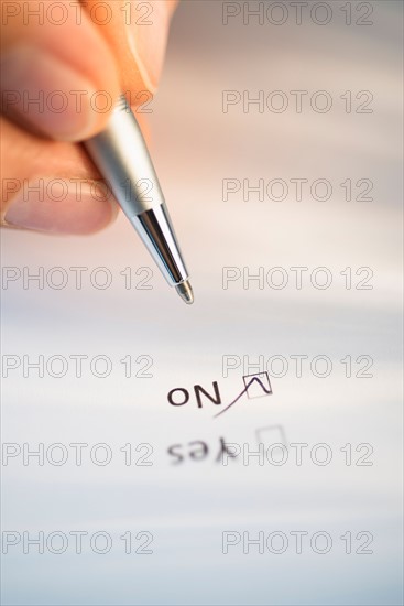 Close-up of hand filling out form.