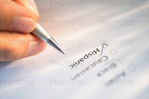 Close-up of hand filling out form.