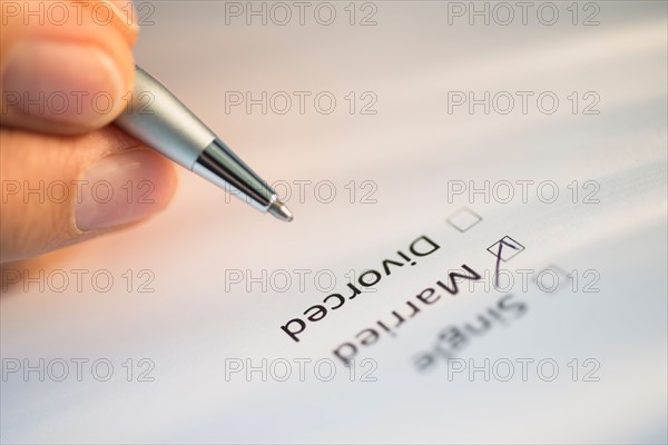 Close-up of hand filling out form.