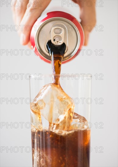 Hand pouring cola.