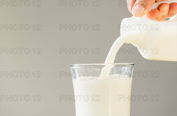 Hand pouring milk.