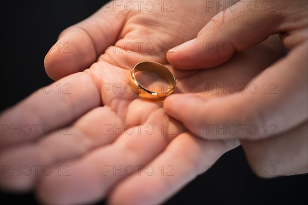 Hand holding wedding ring.