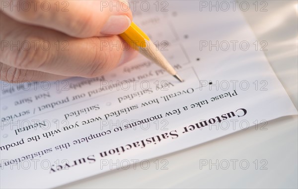 Close-up of hand filling out form.