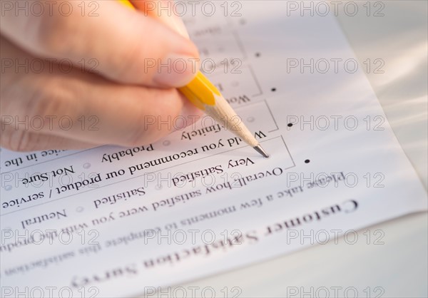 Close-up of hand filling out form.