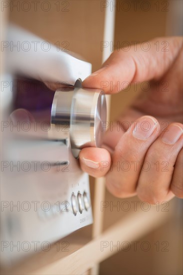 Close-up of hand adjusting audio system.