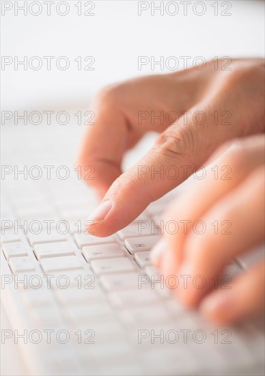 Close-up of hands typing on keyboard.