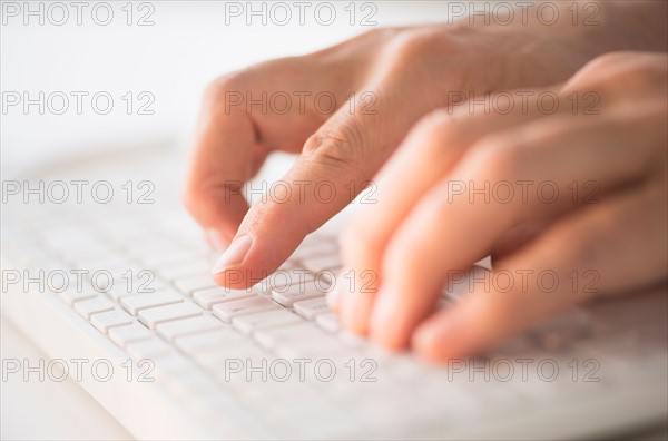 Close-up of hands typing on keyboard.