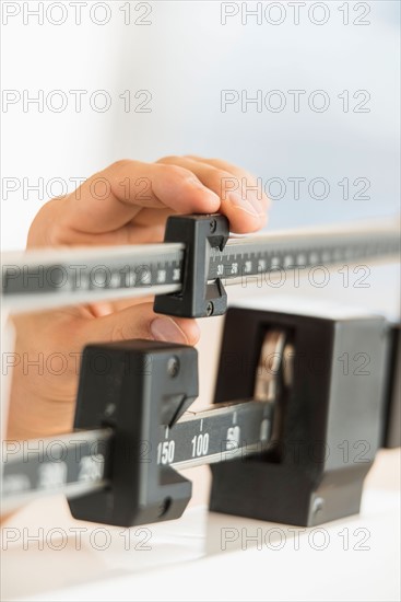 Hand adjusting weight scales.