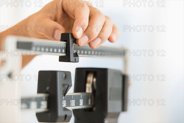 Hand adjusting weight scales.