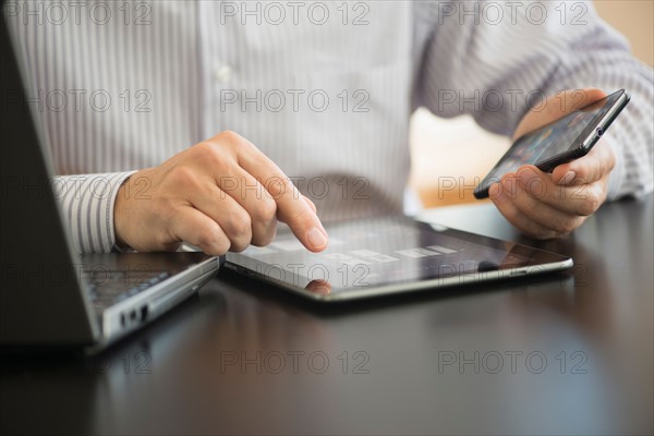 Man using tablet pc, laptop and smartphone.