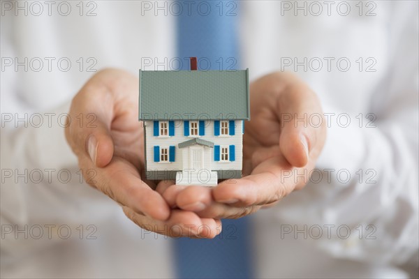 Man holding model house.
