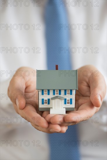 Man holding model house.