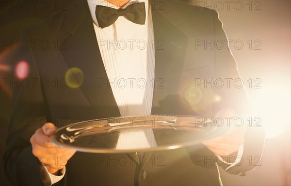 Waiter holding empty tray.