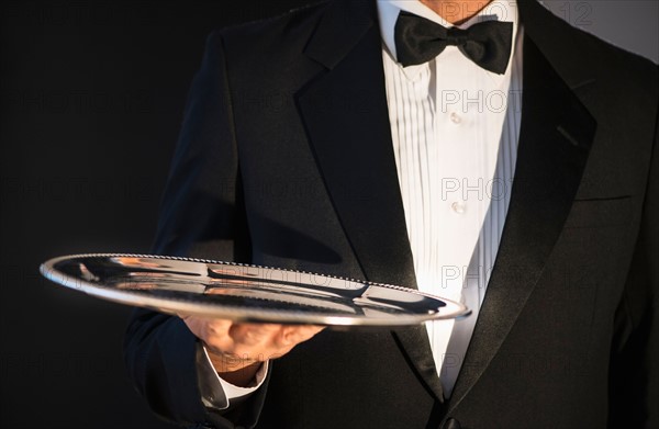 Waiter holding empty tray.