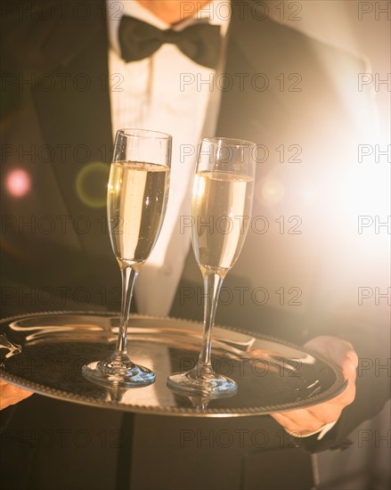 Waiter holding tray with champagne.