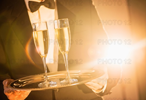 Waiter holding tray with champagne.