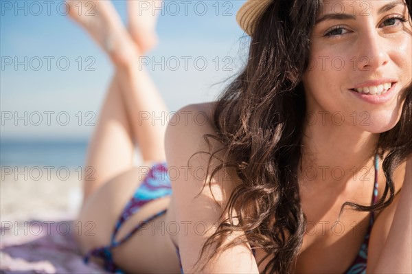 Woman sunbathing on beach. Photo : Jamie Grill