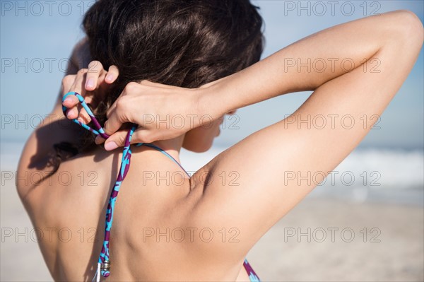 Woman tying bikini top. Photo: Jamie Grill