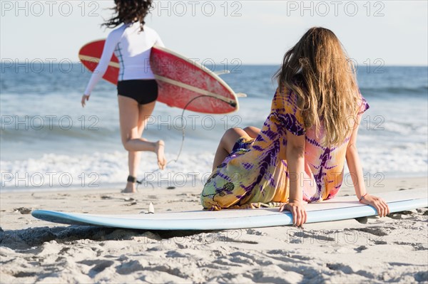 Two female surfers on beach. Photo : Jamie Grill