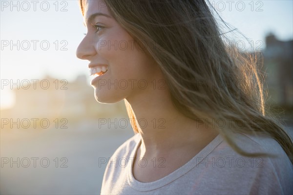 Profile of smiling woman at sunset. Photo : Jamie Grill