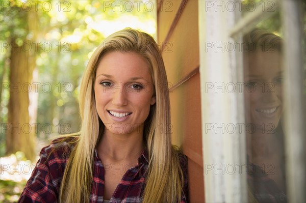 Portrait of young woman standing in front of house. Photo : Jamie Grill