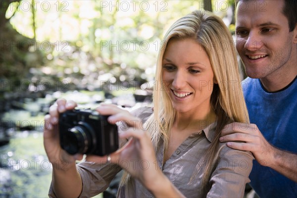 Couple taking picture in forest. Photo : Jamie Grill