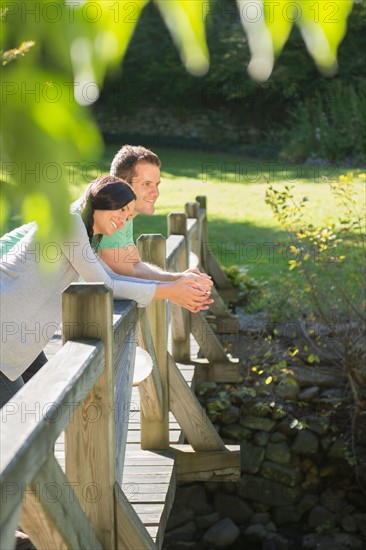 Couple standing on wooden bridge. Photo : Jamie Grill