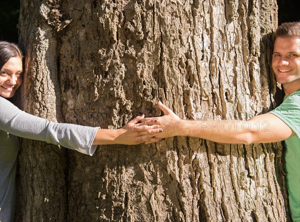 Couple embracing large tree. Photo: Jamie Grill