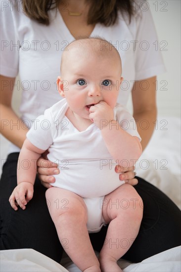 baby boy (2-5 months) held by mother. Photo : Jamie Grill