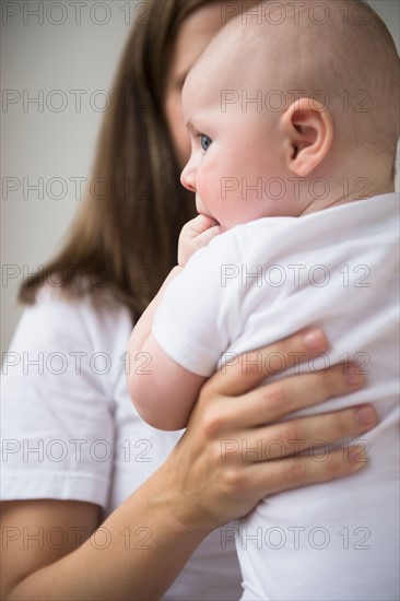 Mother holding baby boy (2-5 months). Photo : Jamie Grill