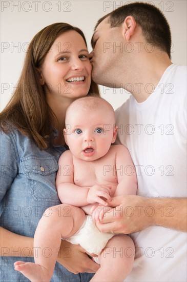 Woman and man holding baby boy (2-5 months). Photo : Jamie Grill