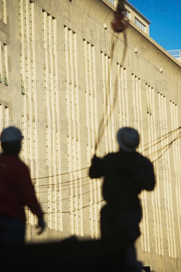 Shadows of construction workers on wall. Photo : Alan Schein