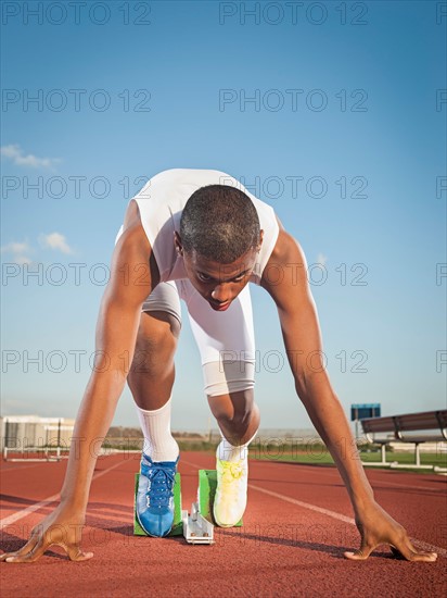 Boy (12-13) preparing for running on starting line.