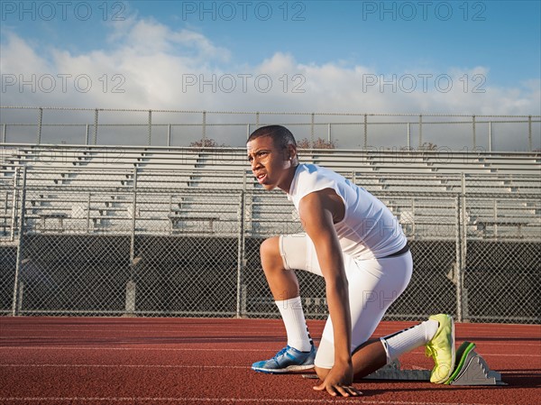 Boy (12-13) preparing for running on starting line.