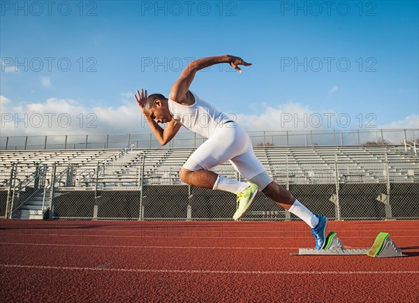 Man starting running on running track.