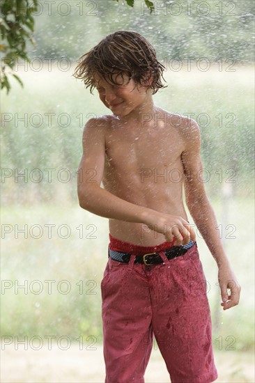 Boy (10-11) playing with splashing water. Photo: pauline st.denis