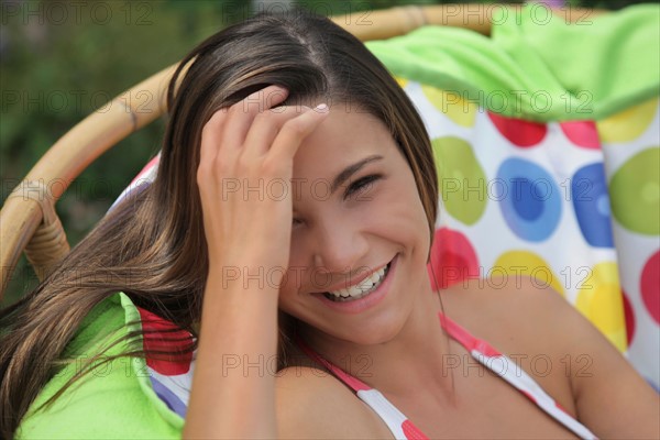 Portrait of girl (12-13) in bikini relaxing in outdoor chair. Photo : pauline st.denis