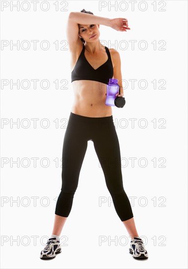 Young woman resting after exercising, studio shot. Photo : Mike Kemp