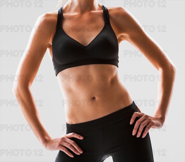 Close up of young woman exercising, studio shot. Photo: Mike Kemp